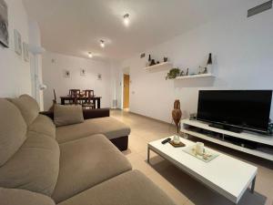 Una sala de estar con un sofá y un televisor de pantalla plana. en 70m2 Apt 2bedrooms 25m2Terrace, 4Pools, 3min beach, en Lloret de Mar