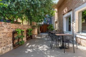 a patio with tables and chairs next to a brick building at Azur Palace Luxury Rooms in Split