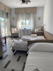 a room with three beds and a table and a couch at Apartamento en Primera Linea in La Herradura