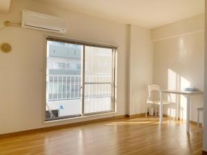 an empty room with a large window and a table at 精品新装修60平米2卧室阳光公寓#干湿分离#高速无限制网路#专用电梯直达#3站直达新宿#最大7人#itk501 in Tokyo +9 photos