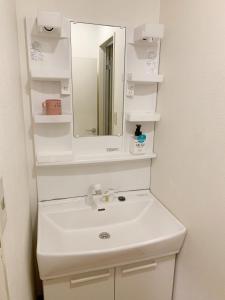 a bathroom with a white sink and a mirror at 精品新装修60平米2卧室阳光公寓#干湿分离#高速无限制网路#专用电梯直达#3站直达新宿#最大7人#itk501 in Tokyo