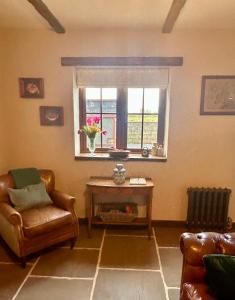 een woonkamer met een stoel en een raam bij NEW -Historic cottage with oak beams & period charm in Llangadog
