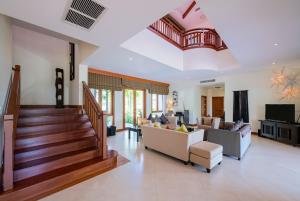 a living room with a staircase and a couch at Laguna Pool Villa - Tranquil Views in Bang Tao Beach