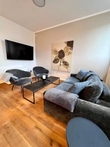 uma sala de estar com um sofá e cadeiras e uma televisão de ecrã plano em Mi Casa 3 Zimmer geschmackvoll zentral in Bremen em Bremen