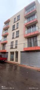 un edificio de apartamentos con un aparcamiento enfrente en Apartamento cómodo y centrico, en Tupiza