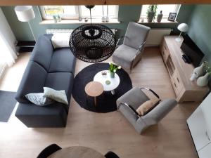 ein Wohnzimmer mit einem Sofa, einem Tisch und Stühlen in der Unterkunft 4-persoons vakantiehuisje Simmerwille in Tzummarum