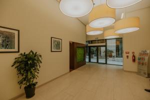 an empty hallway with a potted plant and lights at Hilton Apartment with Sea View in Batumi in Batumi