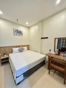 ein Schlafzimmer mit einem großen weißen Bett und einem Tisch in der Unterkunft Phúc Đức Hotel in Thanh Hóa