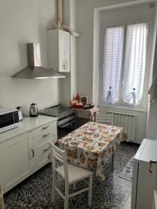 a kitchen with a table and a stove and windows at Chez Thérèse in Sestri Levante