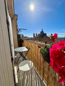 een balkon met een tafel, stoelen en bloemen bij Studio avec vue sur la Major in Marseille