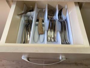 un cajón lleno de tenedores y cucharas en Aimari’s Apartment, en Shkodër