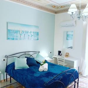 a bedroom with a blue bed and a desk at Regina Stella in Lascari