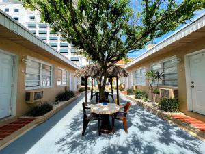 a table and chairs under a tree in a courtyard at St Maurice Beach Inn in Hollywood