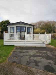 a small house with a white fence in a yard at Roadnights Retreat in Heysham