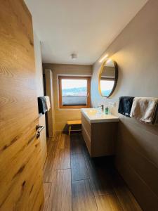 uma casa de banho com um lavatório, um espelho e uma janela em Chic lodge-apartments em Ehrwald
