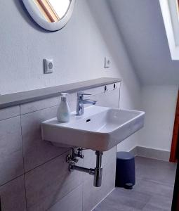 a white sink in a bathroom with a mirror at Ferienwohnung-Ostseestrand-in-Stein-bei-Laboe in Stein