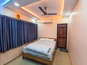 a bedroom with a bed and a ceiling fan at Hotel Arbuda Palace in Bhuj