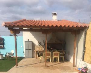einen Pavillon mit einem Tisch und Stühlen auf einer Terrasse in der Unterkunft Villa Evenik in Eretria
