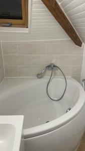 a white bath tub with a hose on top of it at Appartement Aéroport Orly in Athis-Mons