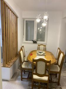 a dining room with a wooden table and chairs at Lovely flat , full furnished with free parking in Prizren
