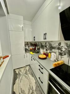a kitchen with white cabinets and a counter top at Lovely flat , full furnished with free parking in Prizren