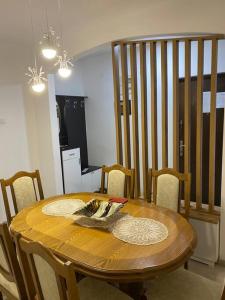 a wooden dining room table with chairs and a staircase at Lovely flat , full furnished with free parking in Prizren