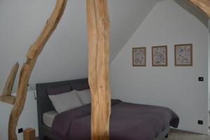 um quarto com uma cama com postes de madeira em La Dépendance d'En Face 