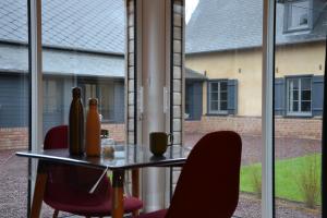 La Dépendance d'En Face : طاولة زجاجية وكراسي أمام النافذة