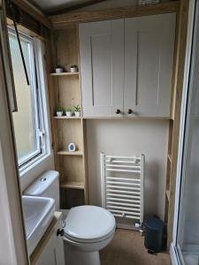 a small bathroom with a toilet and a sink at Roadnights Retreat in Heysham