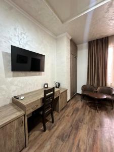 a room with a desk and a television on the wall at Hotel Partiez in Yerevan