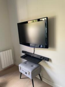 a flat screen tv hanging on a wall at Chambre privée au cœur de Bayeux in Bayeux