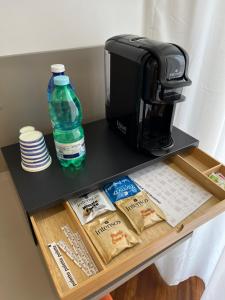 eine Kaffeemaschine auf einem Regal mit einer Kaffeekanne und Wasser in der Unterkunft Maison Grimaldi in Neapel