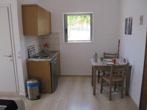 a kitchen with a table and a sink and a table and chair at Lion-Suites in Kalyves +41 photos
