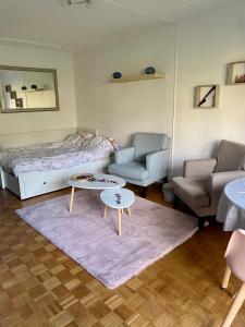 a bedroom with a bed and two chairs and a table at Grand studio avec terrasse et jardin in Saint-Maur-des-Fossés