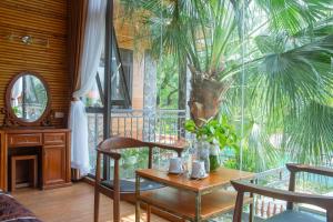 a dining room with a table and a palm tree at Tam Coc Serenity Hotel & Bungalow in Ninh Binh