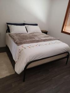 1 dormitorio con 1 cama con sábanas y almohadas blancas en Le Clos de chantecoq, 