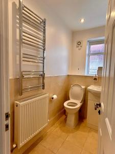 a bathroom with a toilet and a sink at Nature Inspired Bungalow with 3 rooms - 10 mins from Manchester Airport in Timperley