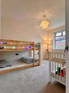 - une chambre avec 2 lits superposés et une fenêtre dans l'établissement Nature Inspired Bungalow with 3 rooms - 10 mins from Manchester Airport, à Timperley