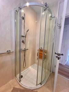 um chuveiro com uma caixa de vidro na casa de banho em Nature Inspired Bungalow with 3 rooms - 10 mins from Manchester Airport em Timperley