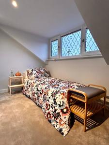um quarto com uma cama com um cobertor e uma janela em Nature Inspired Bungalow with 3 rooms - 10 mins from Manchester Airport em Timperley