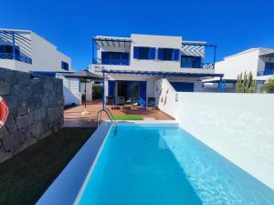 a villa with a swimming pool in front of a house at Villa Valperal, en Lanzarote in Playa Blanca