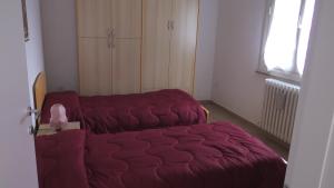 un sofá rojo en una habitación pequeña con ventana en Casa Travaglini en Fano