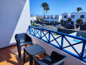a balcony with two chairs and a table and a street at Villa Valperal, en Lanzarote in Playa Blanca