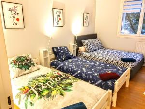 um quarto com duas camas e um sofá em La Casa Picasso em Villepinte