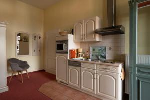 eine Küche mit weißen Schränken und einem Waschbecken in der Unterkunft Villa Stock in Heringsdorf
