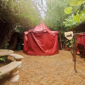 uma tenda vermelha sentada num campo de feno em Le Camp du Chevalier em Valençay