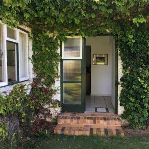 uma entrada para uma casa com uma porta verde em Honeywood Farm em Heidelberg