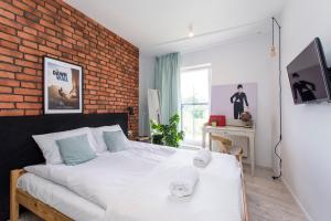 ein Schlafzimmer mit einem Bett und einer Ziegelwand in der Unterkunft City Center - Granary Island by Apartmore in Danzig