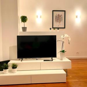 un centro di intrattenimento bianco con TV a schermo piatto di Lazy Time Apartment a Roma