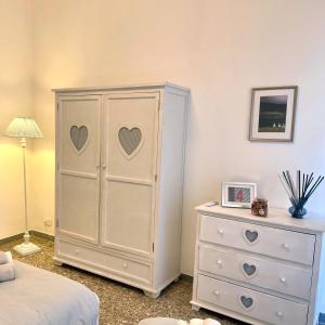 une armoire blanche avec des cœurs à côté d'une commode dans l'établissement Lazy Time Apartment, à Rome